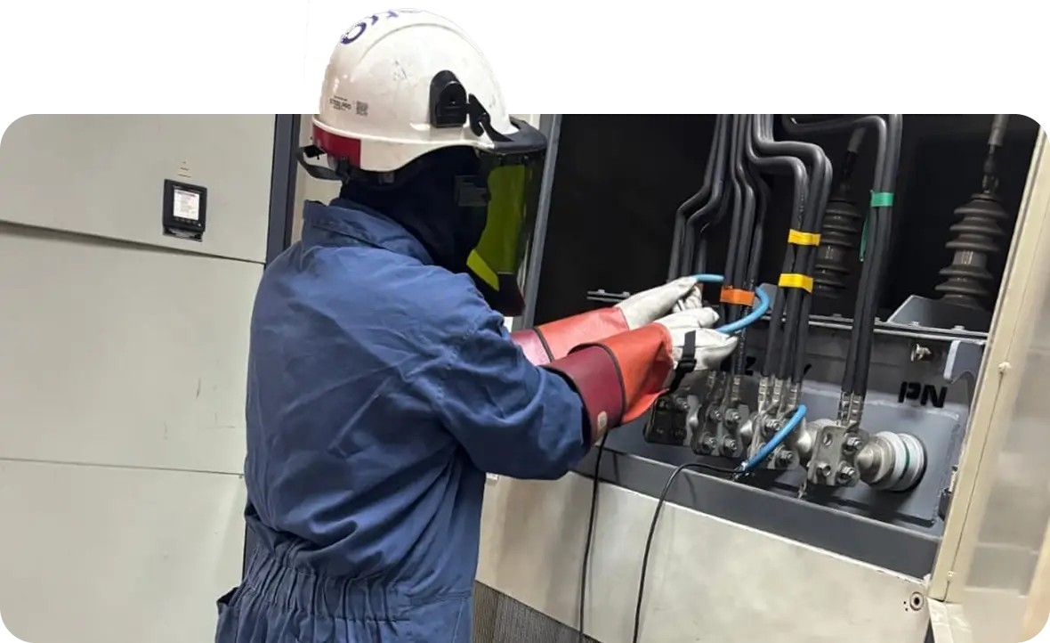 Técnico de Melectra con equipo de protección dieléctrico realizando pruebas y conexiones en celdas de media tensión durante un proceso de mantenimiento preventivo.